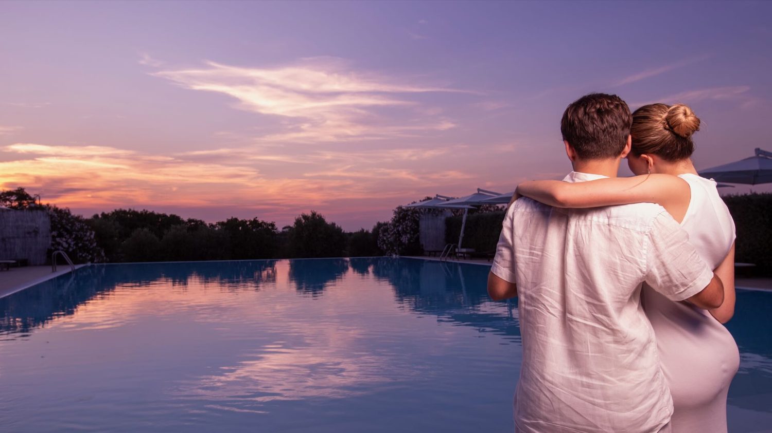 Coppia al tramonto in piscina